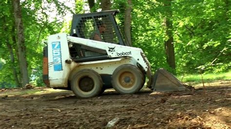 using a skid steer to level land|leveling ground with a bobcat.